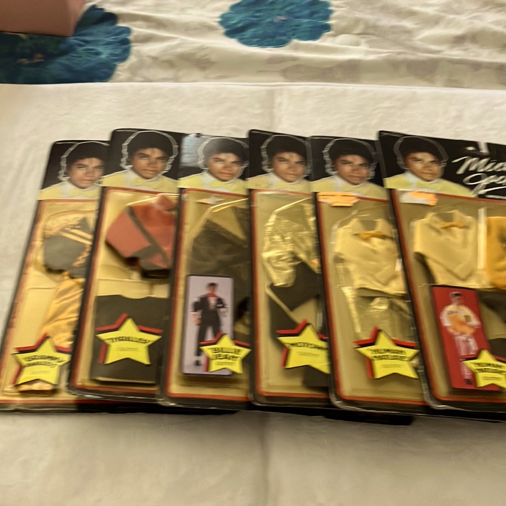 Six Unopened MICHAEL JACKSON OUTFITS. Fits all 12” dolls. Sold separate $55.